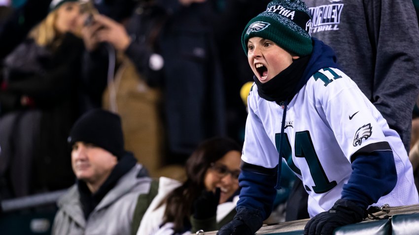 Young Philadelphia Eagles fan yelling in winter hat.