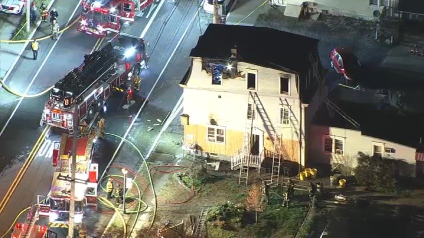 Firefighters surround fire-damaged building