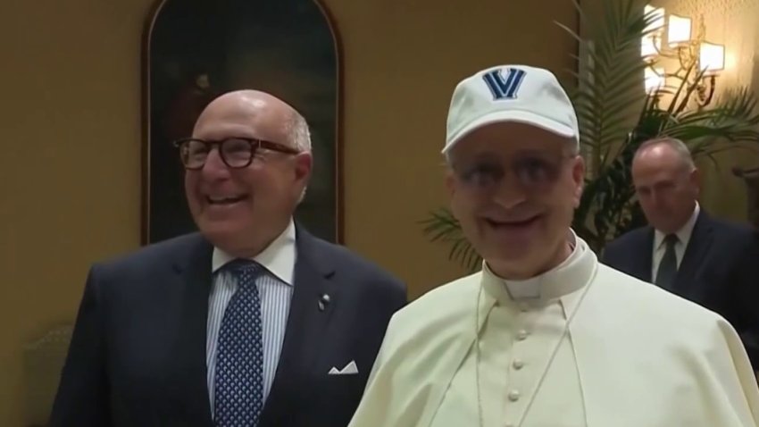 Pope Leo XIV wears a Villanova hat that he received as a gift from the National Italian American Foundation.